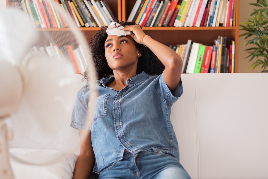 woman at home suffering from no air conditioning after not knowing the top causes of AC failure.