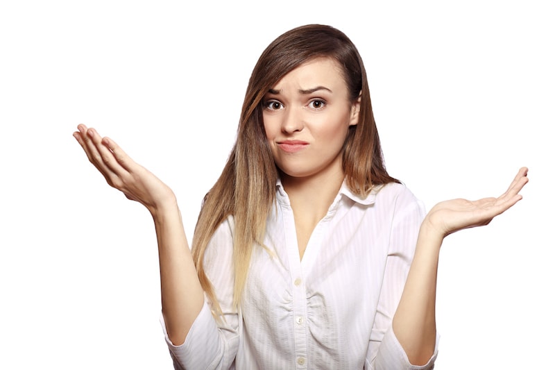 portrait of young woman shrugging her hands isolated on white background in photostudio