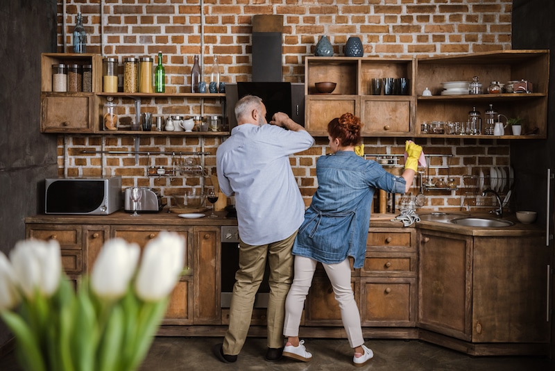 Back view of mature couple having fun while washing dishes in kitchen. Do you need a spring maintenance check in Davidson