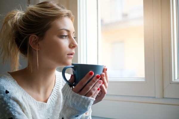 why is my furnace pilot light going out?, woman with coffee mug near window