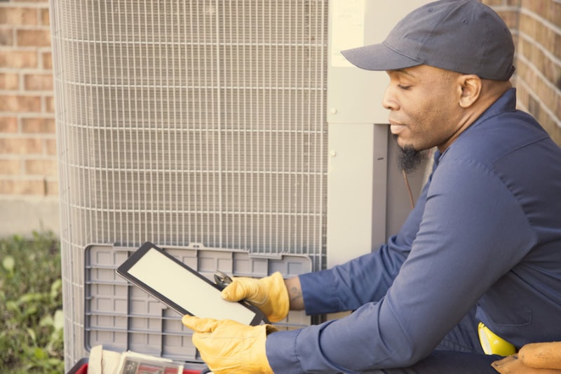 3 Tips To Prevent An AC Breakdown During A Heat Wave. air conditioner repairman at work.